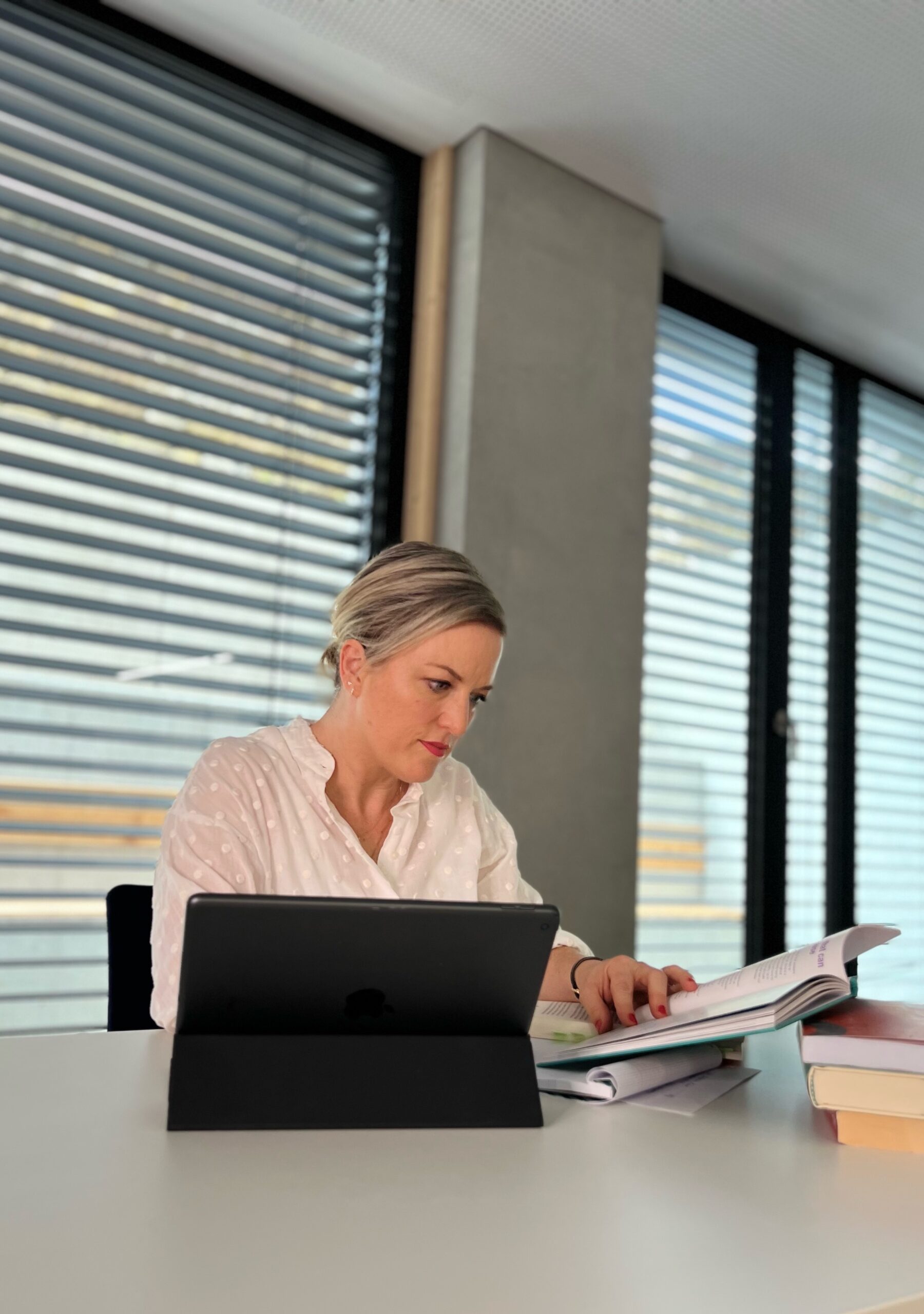 Ann Katrin Pause recherchiert mit Büchern. 